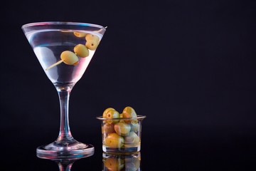Cocktail martini with olives on table