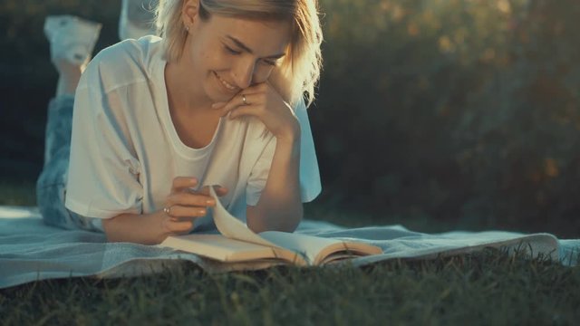 Attractive girl reading a book at sunset