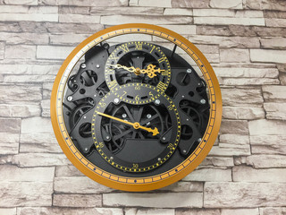 Vintage clock hanging on brick pattern wall background.