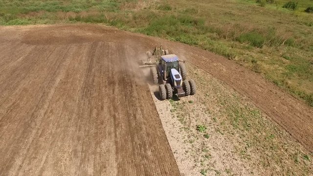 Aerial view of tractor cultivating wheat stubble field