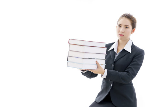 Dissatisfied young Asian businesswoman in black suit and white t-shirt holding books isolated on white background