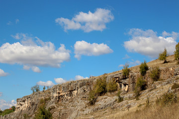 Fototapeta na wymiar Landscape with beautiful fluffy clouds over autumn rocky ridges