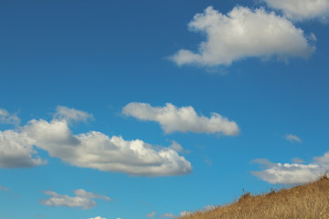 Landscape with beautiful fluffy clouds over autumn field
