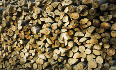 Natural wooden background - closeup of chopped firewood. Firewood stacked and prepared for winter Pile of wood logs