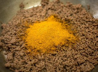 Taco spice mix on minced meat. Seasoning in frying in pan.