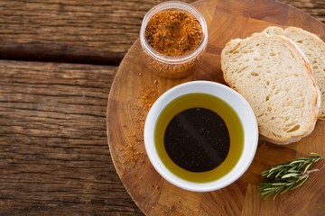 Olive oil with bread and spice powder on table