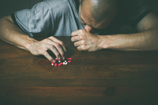 Depressed man, Depressed man suffering from suicidal depression want to commit suicide by taking strong medicament drugs and pills