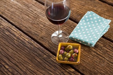Close-up of marinated olives with glass of wine