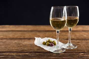 Close-up of olives with glasses of wine