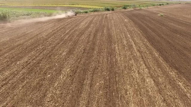 Aerial view of tractor cultivating wheat stubble field