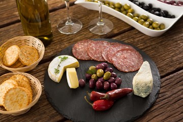 Close-up of marinated olives with bottle of wine and food