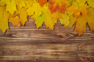 Naklejka na ściany i meble autumn background. yellow leaves on a brown wooden background