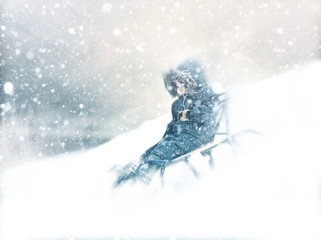 Boy sliding snowy hill