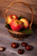 Beautiful juicy apples in a basket on a wooden table