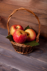 Beautiful juicy apples in a basket on a wooden table