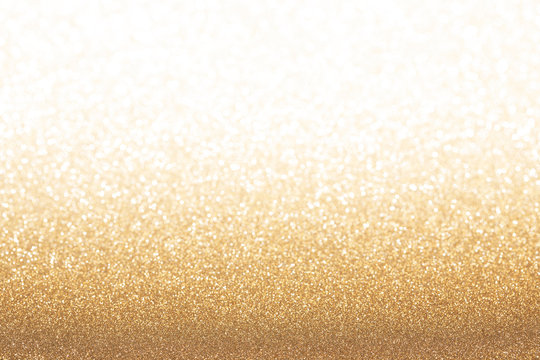 Golden (yellow) glitter background. Sparkle texture. Abstract gradient background blurred for New Years or Christmas holiday