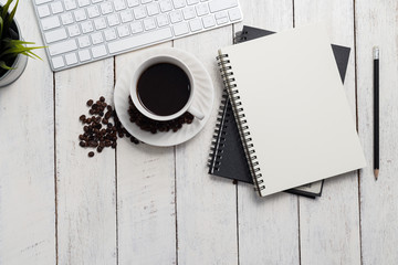 Empty notebook, computer and coffee on wooden table