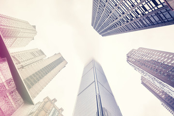 Fototapeta na wymiar Looking up at skyscrapers in clouds, color toning applied, Chongqing, China.