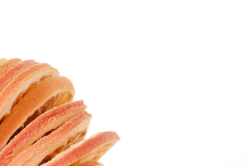 Stack of dried oranges arranged in corner on white background