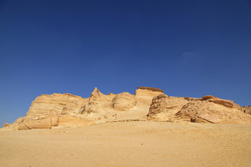 Fototapeta na wymiar Berge im Tal der Wale in der Wüste von Ägypten mit blauem Himmel