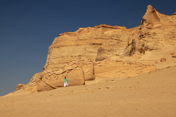 Tourist alleine in der Wüste an einem Berg im Tal der Wale