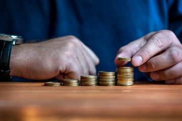 Man stacking money as concept for success or savings, investment and accounting