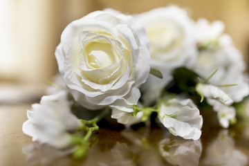 White roses wedding bouquet of flowers shot close up on a wooden table with a shallow depth of field at a tradtional English Wedding