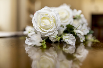 White roses wedding bouquet of flowers shot close up on a wooden table with a shallow depth of field at a tradtional English Wedding