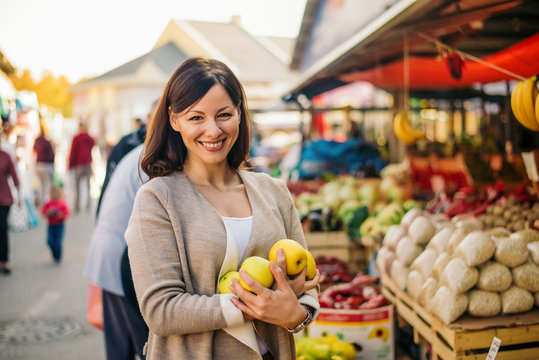 Woman At The Market, Holding Apples.