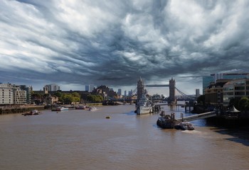River Thames in London, with Tower Bridge in the distance with a cloudy ominous sky