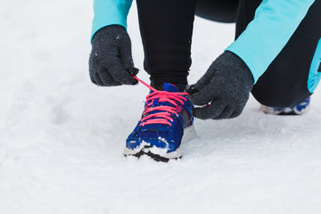 Tying sport shoes in snow