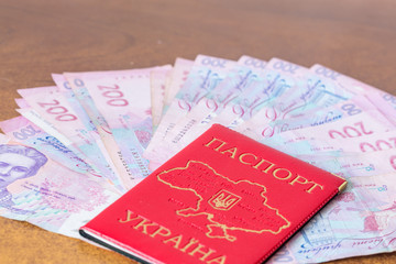 Ukrainian domestic passport with hryvnias on table side view