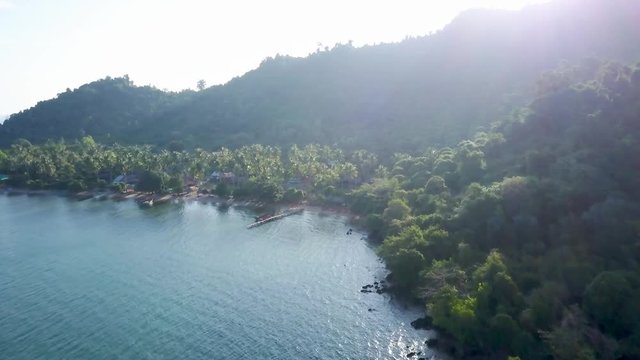At sunrise over the mountain, the aerial camera looks at the horizon and shows the coastline of Koh Tonsay, Cambodia.
