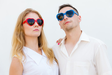 Man and woman wearing heart shape sunglasses