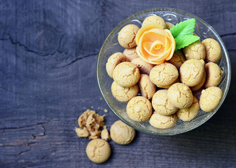 Amaretti cookies in a glass bowl on old wooden background.Italian amarettini biscuits.Amarettini cookies.Tasty Italian amaretti biscuits.Selective focus.