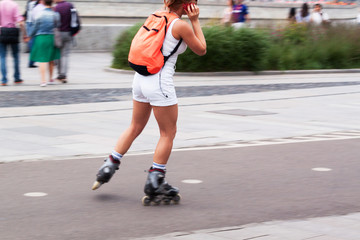 beautiful sports girl skates in a summer city park