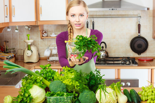 Woman in kitchen having vegetables holding shopping basket
