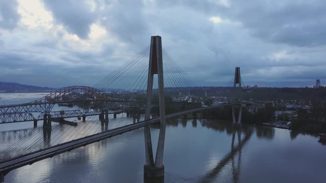 Aerial 4k footage of Pattullo and Skytrain Bridge going across Fraser River between Surrey and New Westminster. Taken in Greater Vancouver, British Columbia, Canada.