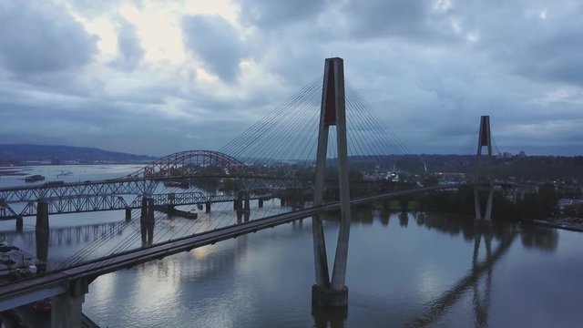 Aerial 4k footage of Pattullo and Skytrain Bridge going across Fraser River between Surrey and New Westminster. Taken in Greater Vancouver, British Columbia, Canada.