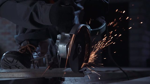 Angle grinder producing sparks while cutting metal