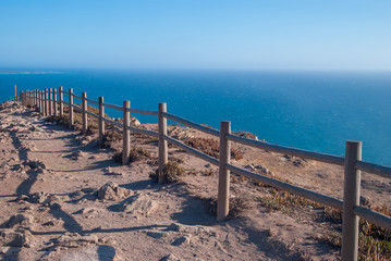 Fototapeta premium View od Cabo da Roca in Sintra - Roca Cape - cliffs and fence at sunset