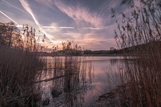Sonnenuntergang an einem Wintertag &uuml;ber einem Weiher- Zeitraffer