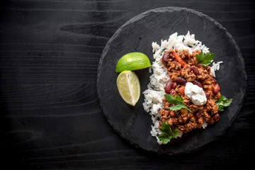 Sliced lamb with sauce and rice served on dark plate,blank space