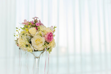 Beautiful wedding floral decoration on a table in a restaurant.White tablecloths, bright room.