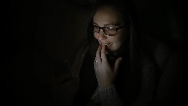 Beautiful woman using smartphone at home late night, very surprised, emotions