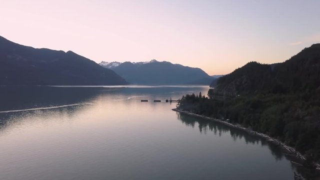 Aerial 4k drone footage of Howe Sound during a vibrant and colorful summer sunset. Taken North of Vancouver, British Columbia, Canada.