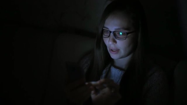 Beautiful woman using smartphone at home late night, very surprised, emotions