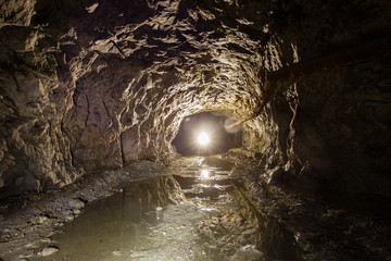 Underground quartz ore mine shaft tunnel with backlight - obrazy, fototapety, plakaty