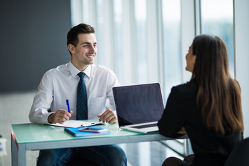 Business people Having Meeting Around Table In Modern Office. Young man listen woman in office