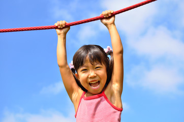 Fototapeta premium 公園の遊具で遊ぶ女の子